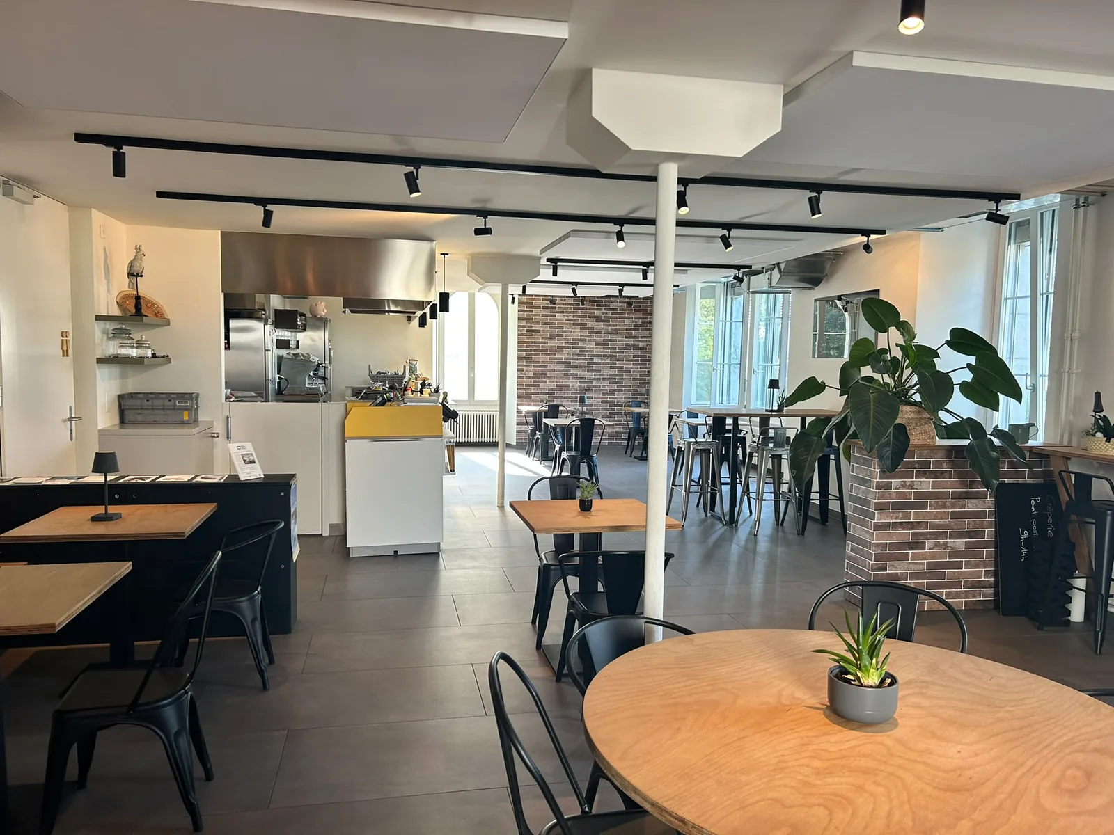 La salle de L'Atelier et sa cuisine ouverte en arrière-plan