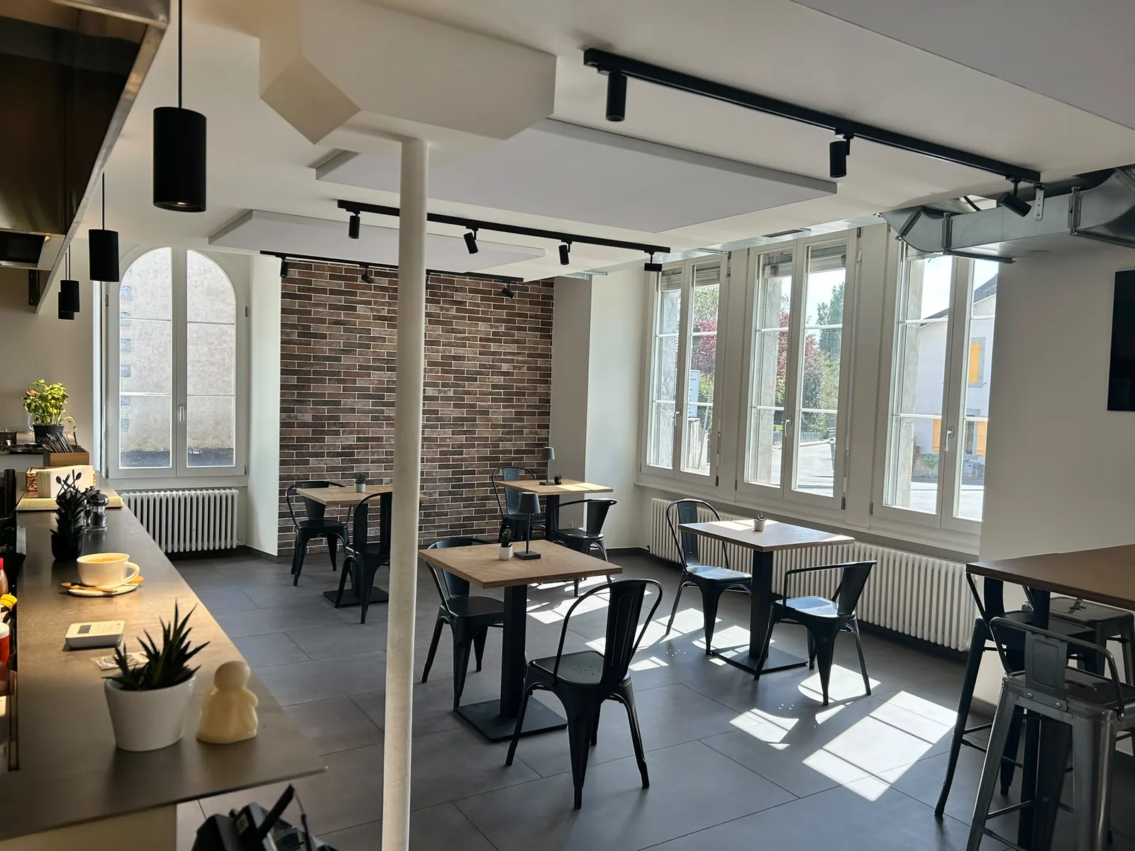 La salle baignée de lumière, tables le long des fenêtres